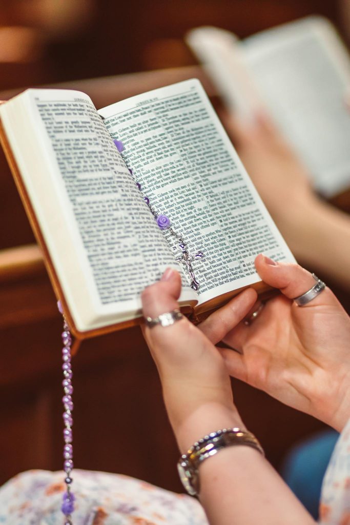 Bible study questions and answers. Adult holding an open Bible.